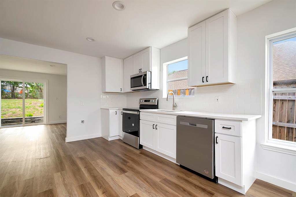 a kitchen with granite countertop white cabinets and white appliances