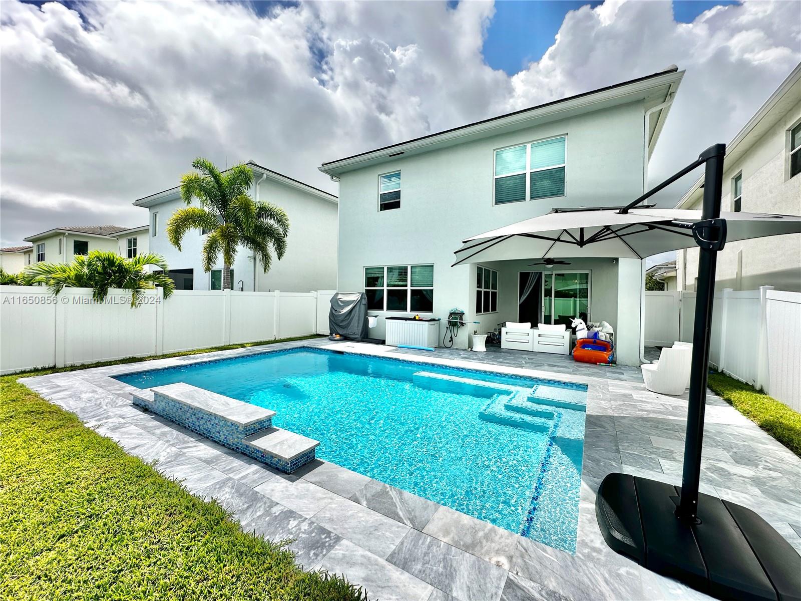 a view of a house with backyard and sitting area