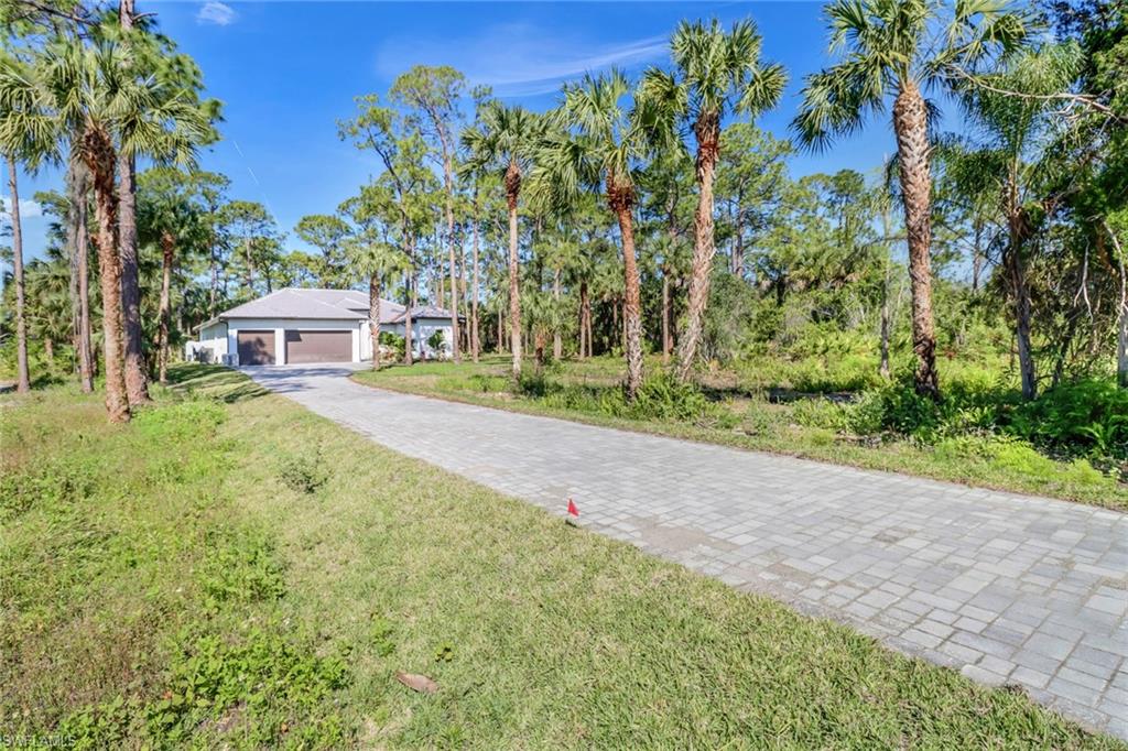 a view of a house with a yard and pathway