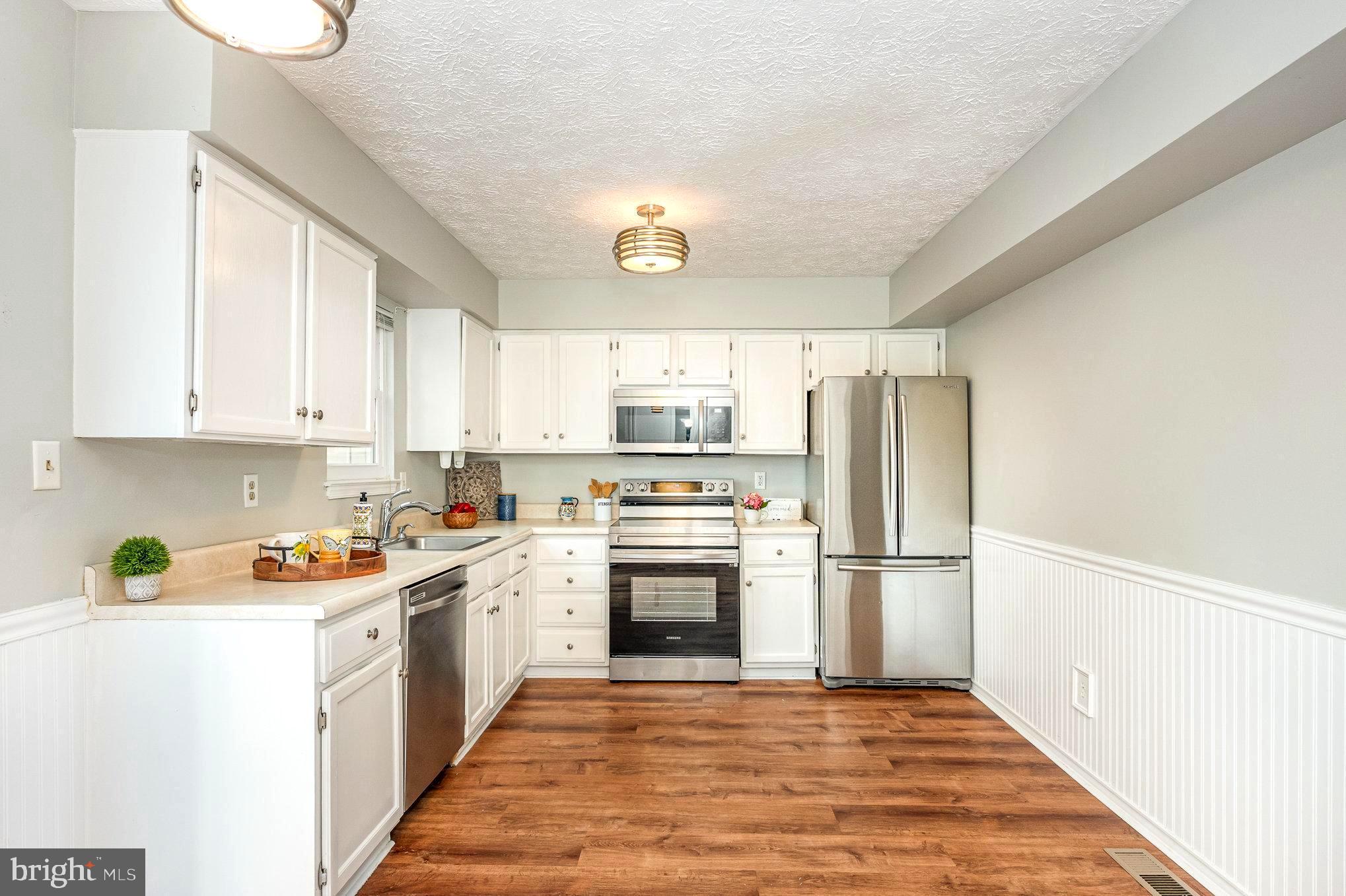 a kitchen with stainless steel appliances granite countertop a refrigerator sink and cabinets