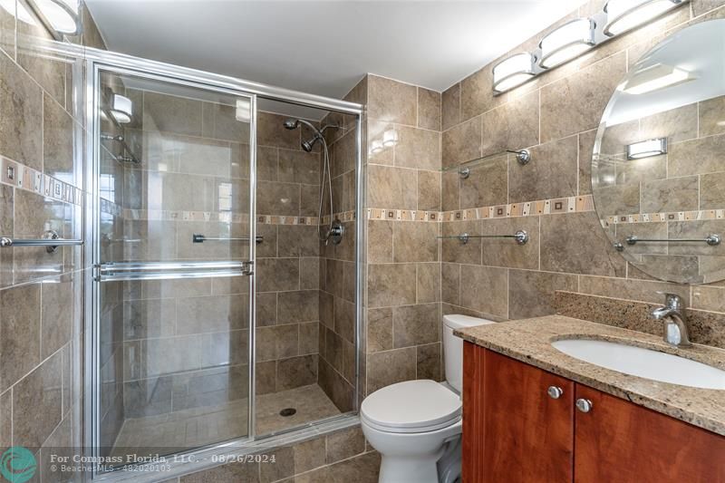 a bathroom with a shower and a toilet sink