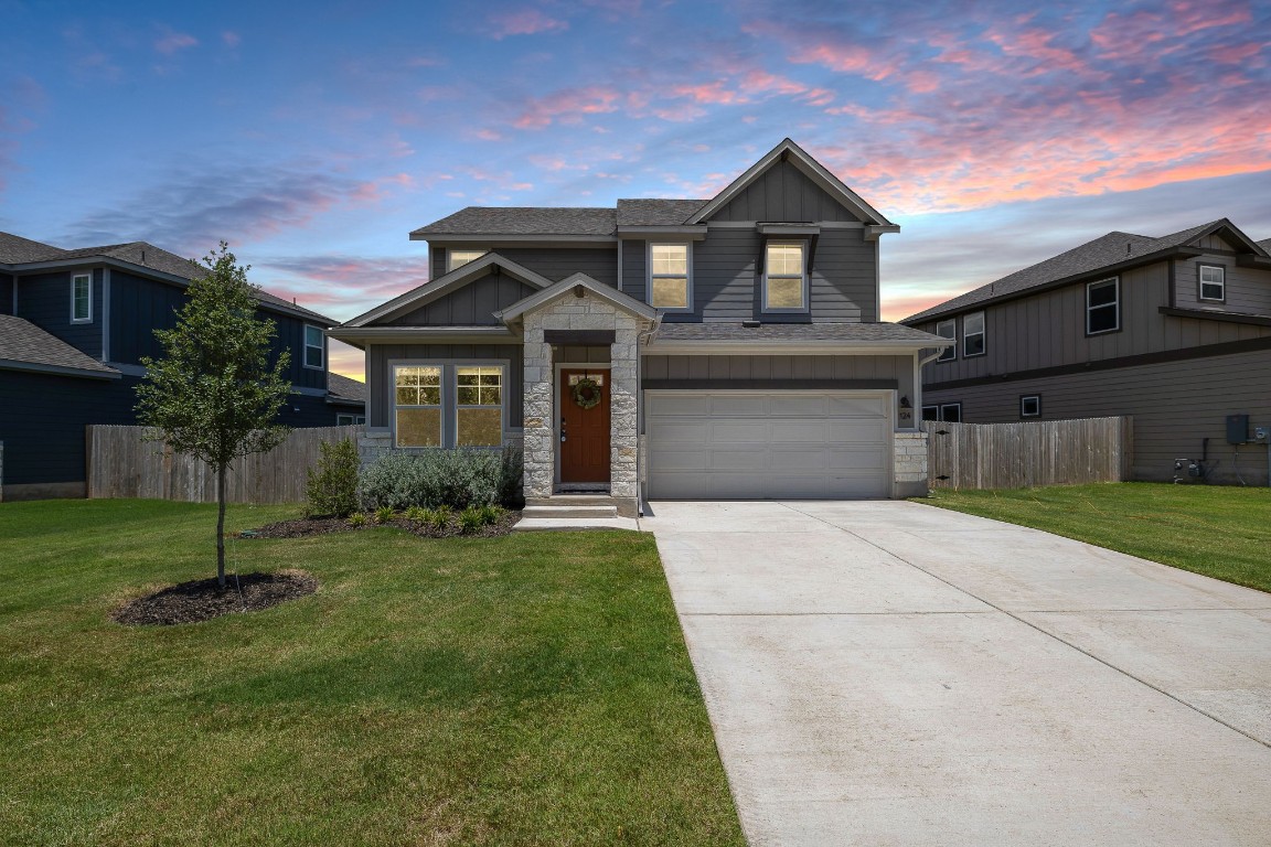 a front view of a house with a garden and yard