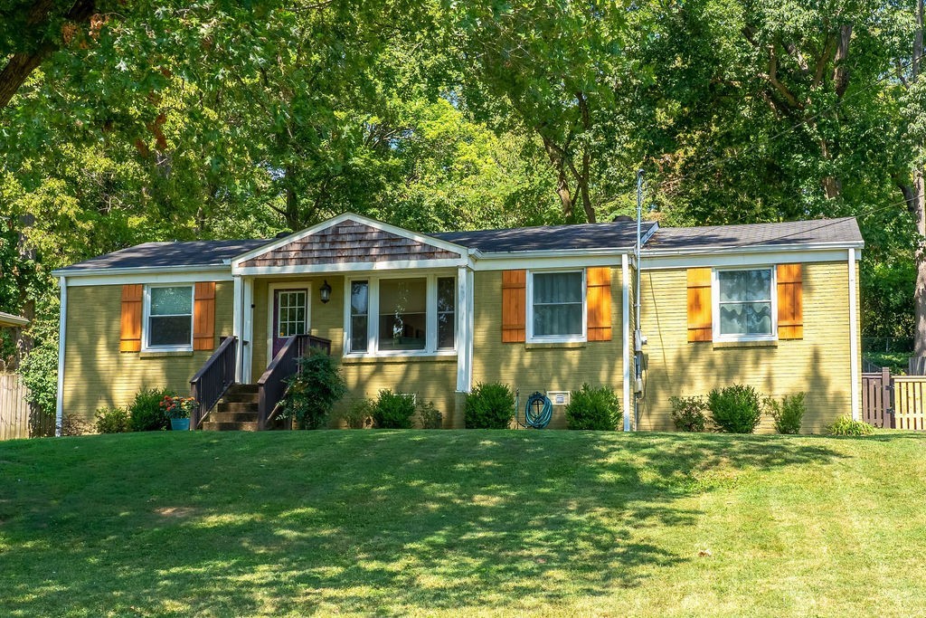 a front view of house with yard and green space