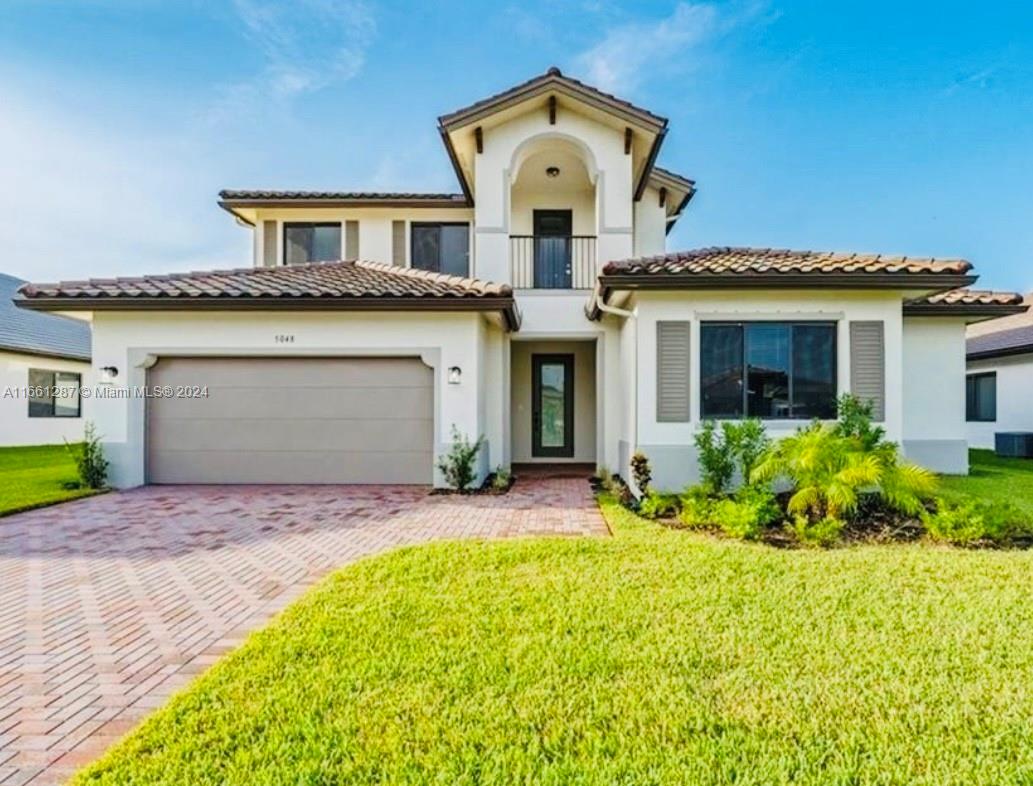 a front view of a house with a yard and garage