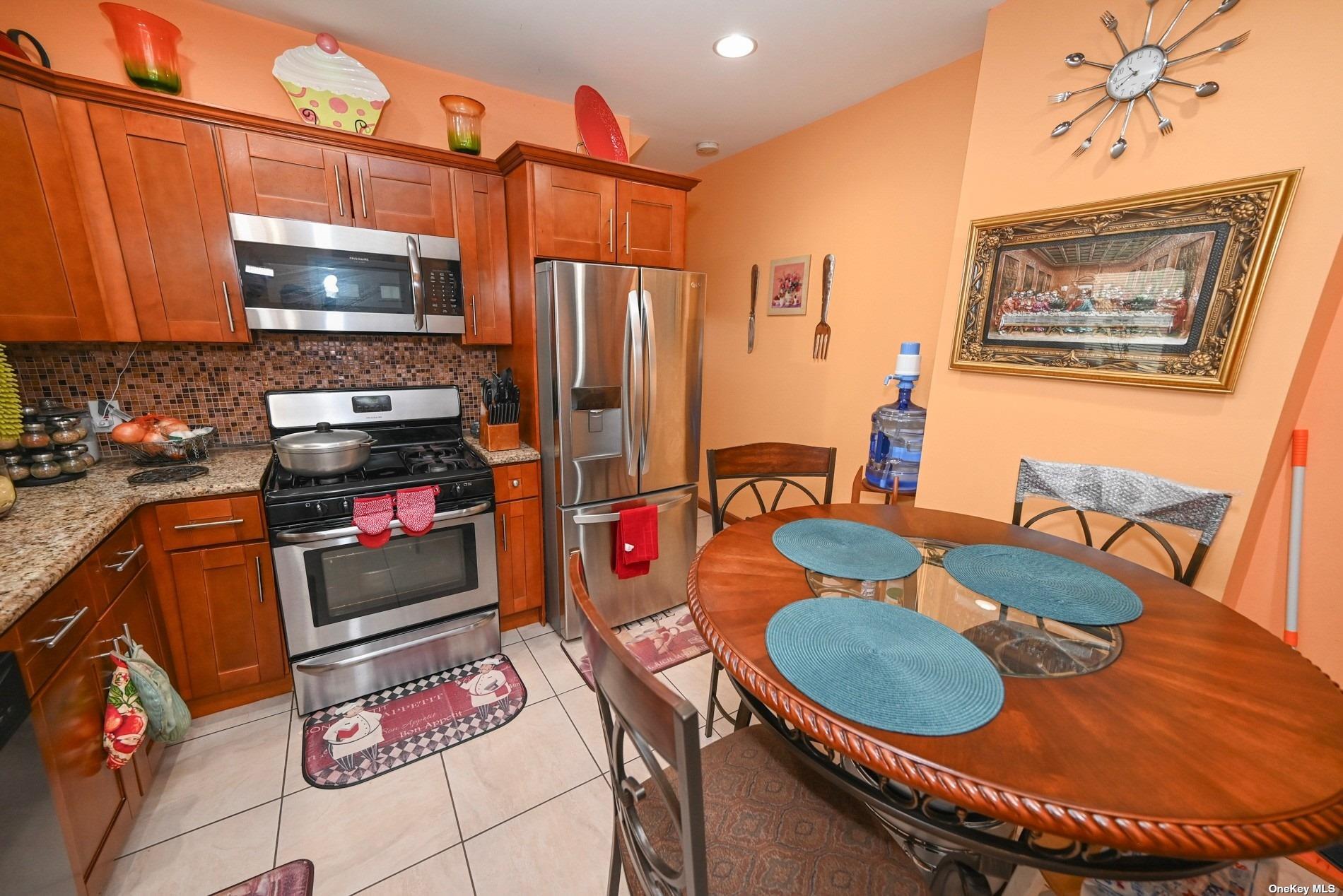 a kitchen with stainless steel appliances granite countertop a sink a microwave and chairs