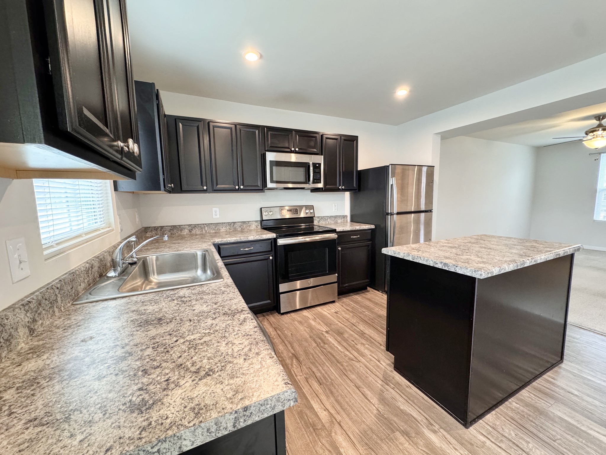 a kitchen with stainless steel appliances granite countertop a sink stove and refrigerator