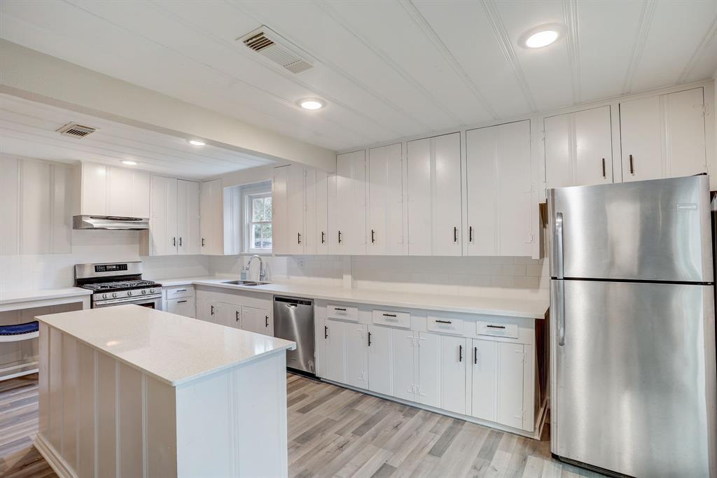 a kitchen with a white refrigerator a sink dishwasher and a stove top oven with wooden floor