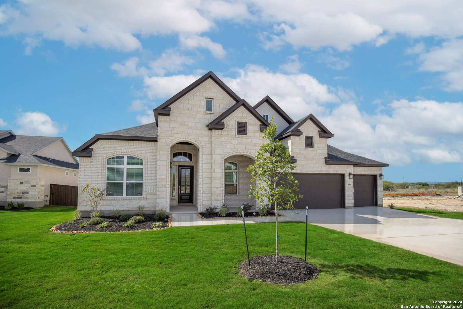 a front view of a house with a garden and yard