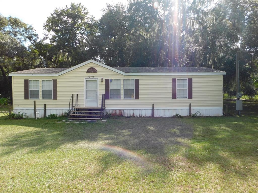 a front view of a house with a garden and yard