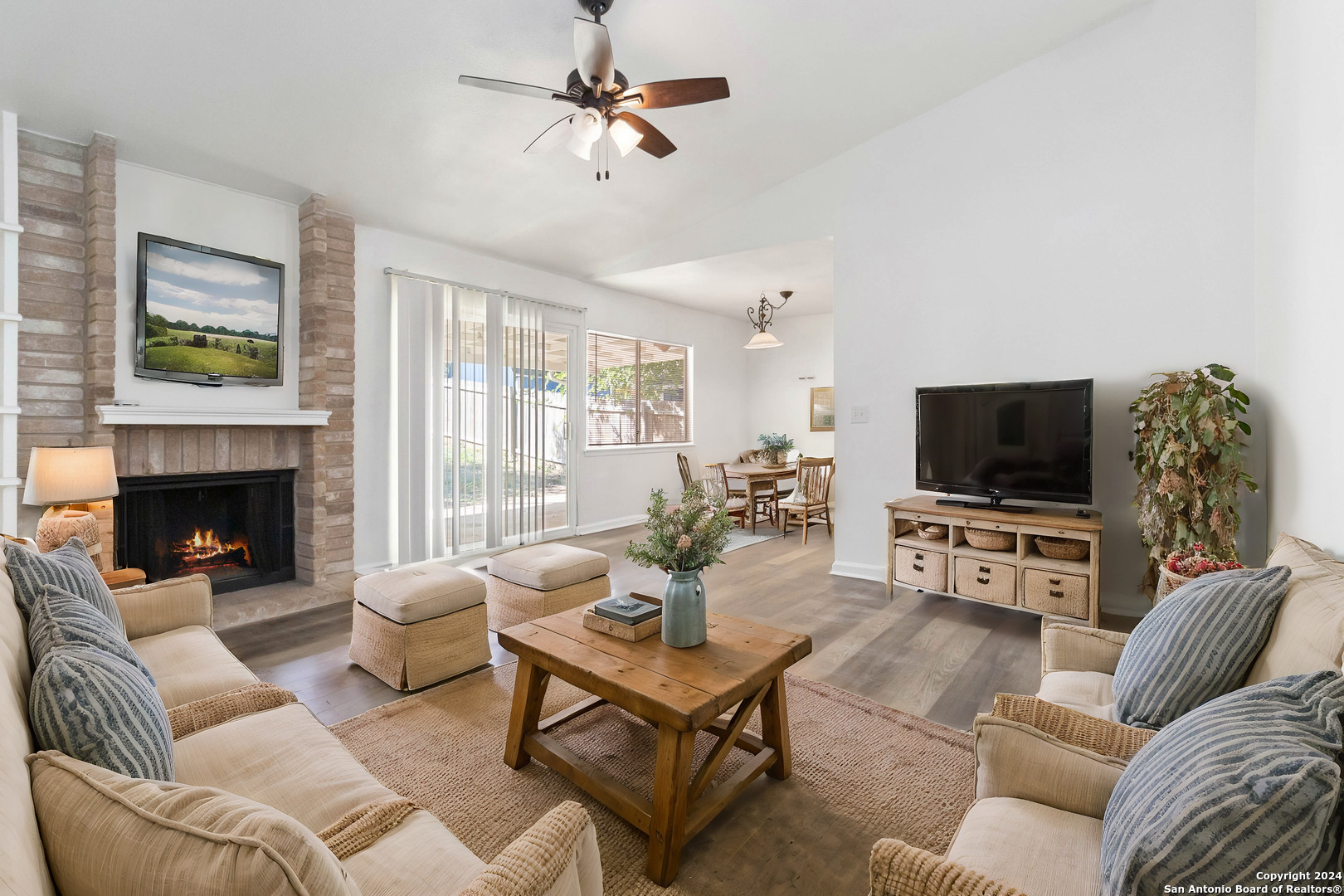 a living room with furniture a flat screen tv and a fireplace