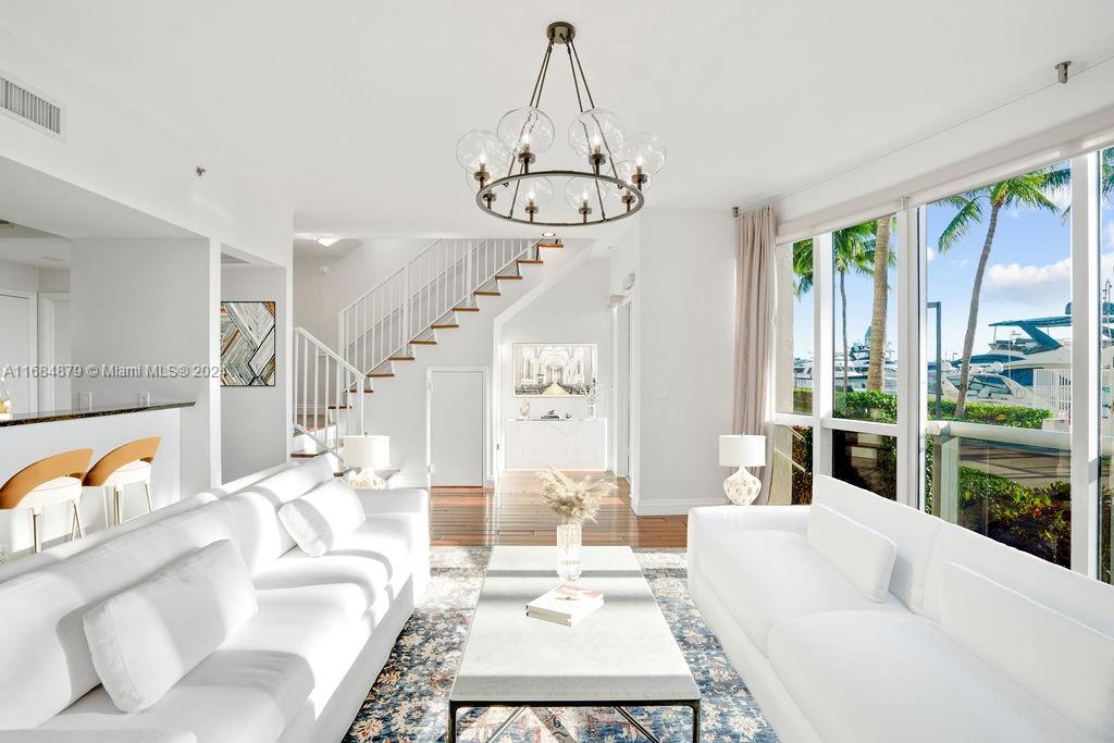 a living room with furniture a large window and a chandelier