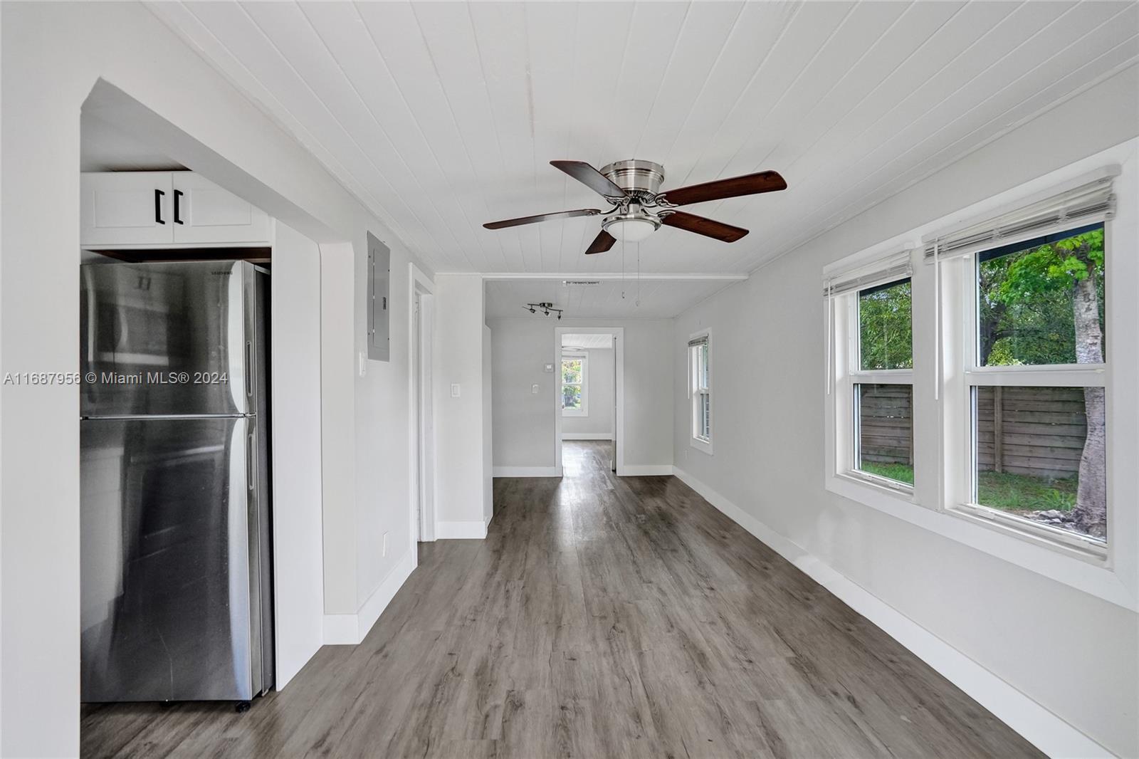 a view of a hallway with wooden floor and a window