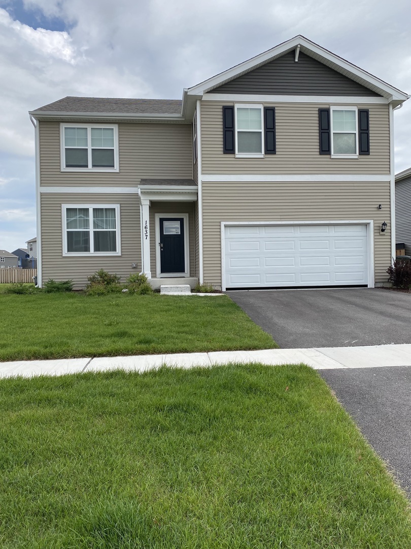 a front view of a house with a yard and garage