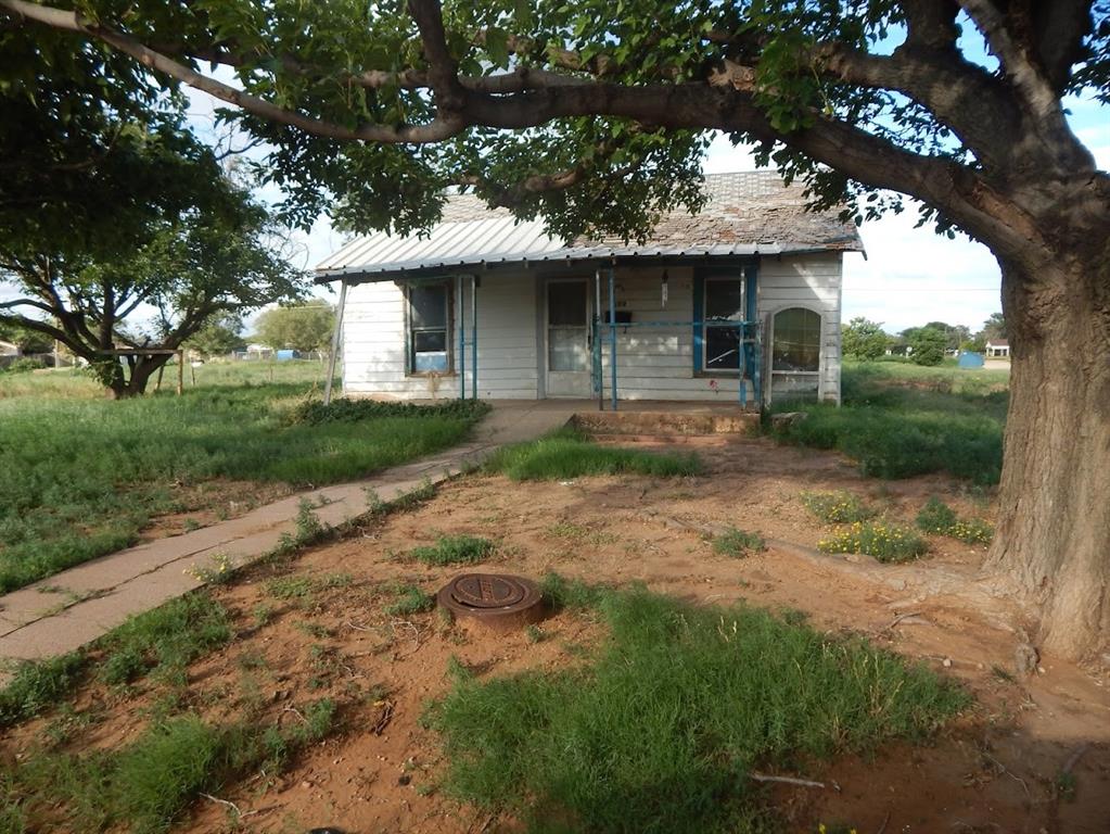 a front view of a house with a garden and trees