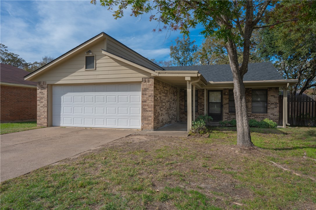 Single story home featuring a garage and a front y