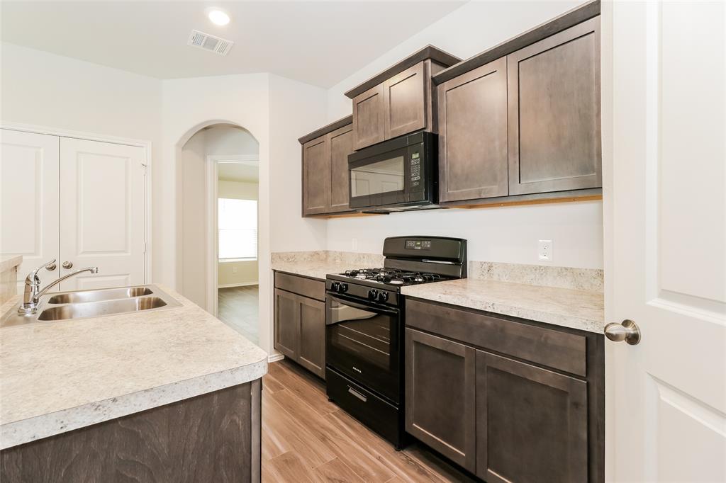 a kitchen with stainless steel appliances granite countertop a sink stove and microwave