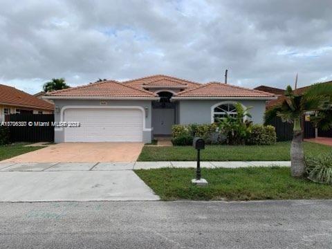 a front view of a house with a yard and a garage