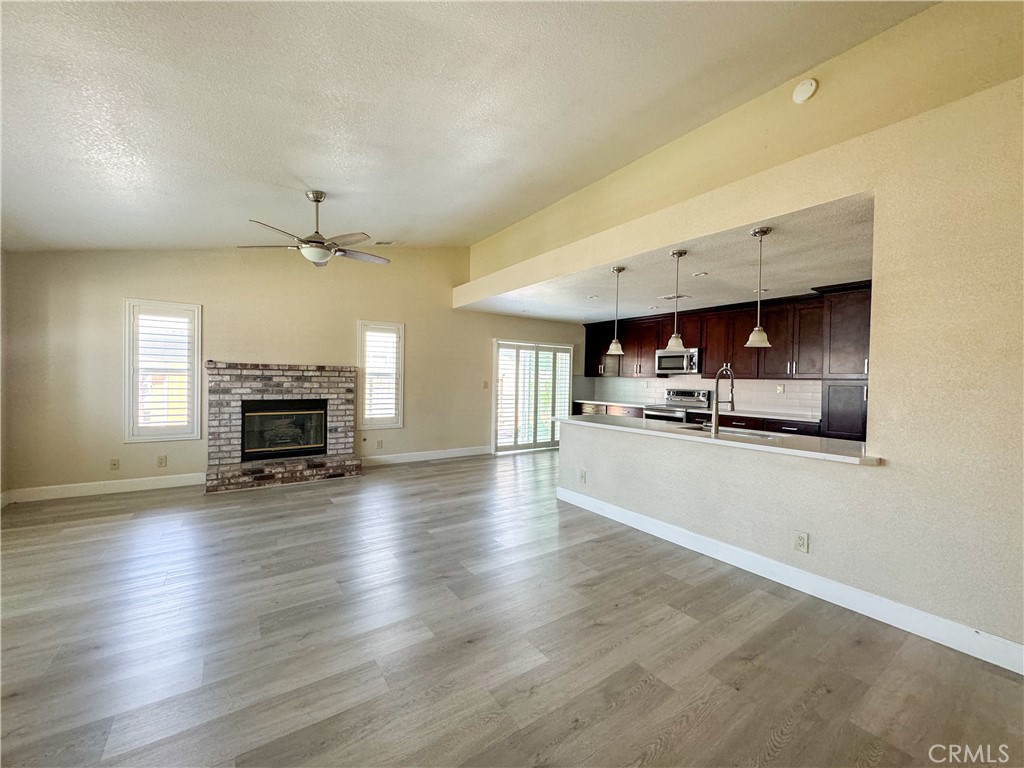 a view of kitchen and livingroom with furniture wooden floor and fireplace