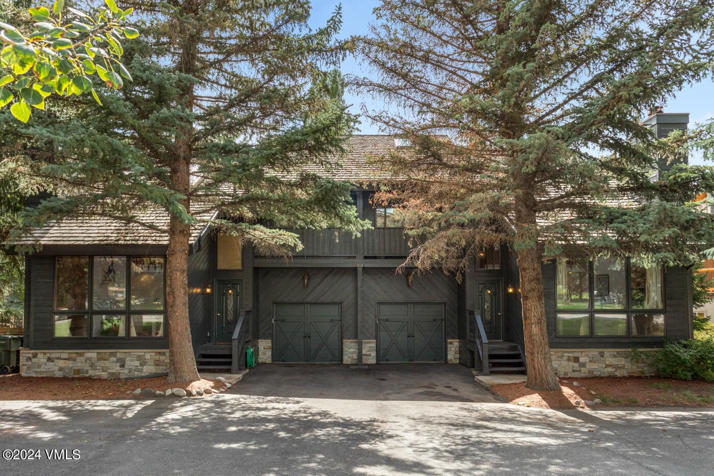 a view of a brick house with large windows and a large tree