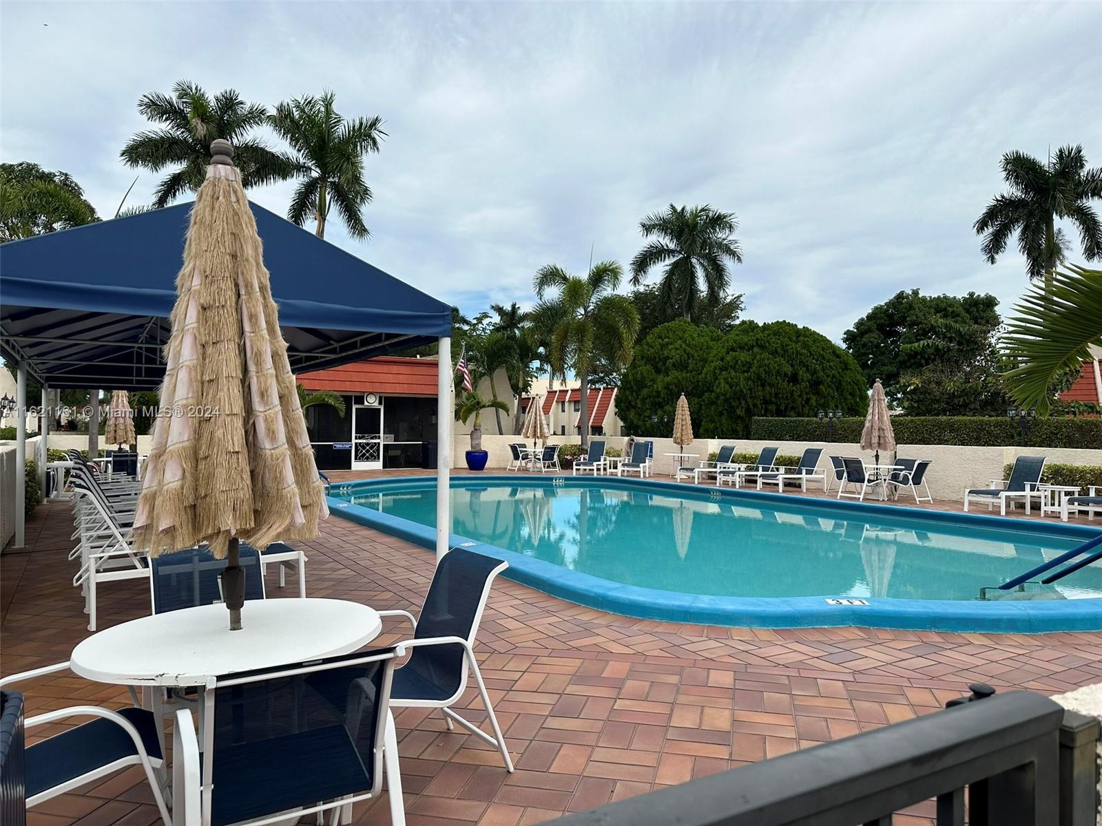 a view of a backyard with a patio and swimming pool