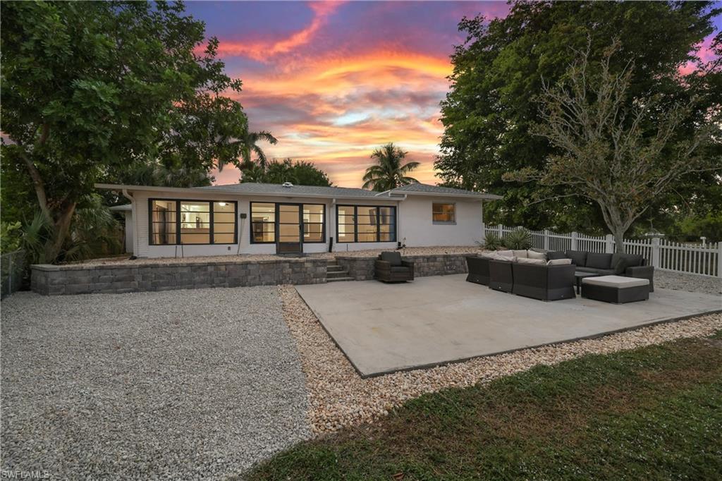 a view of a house with backyard and sitting area