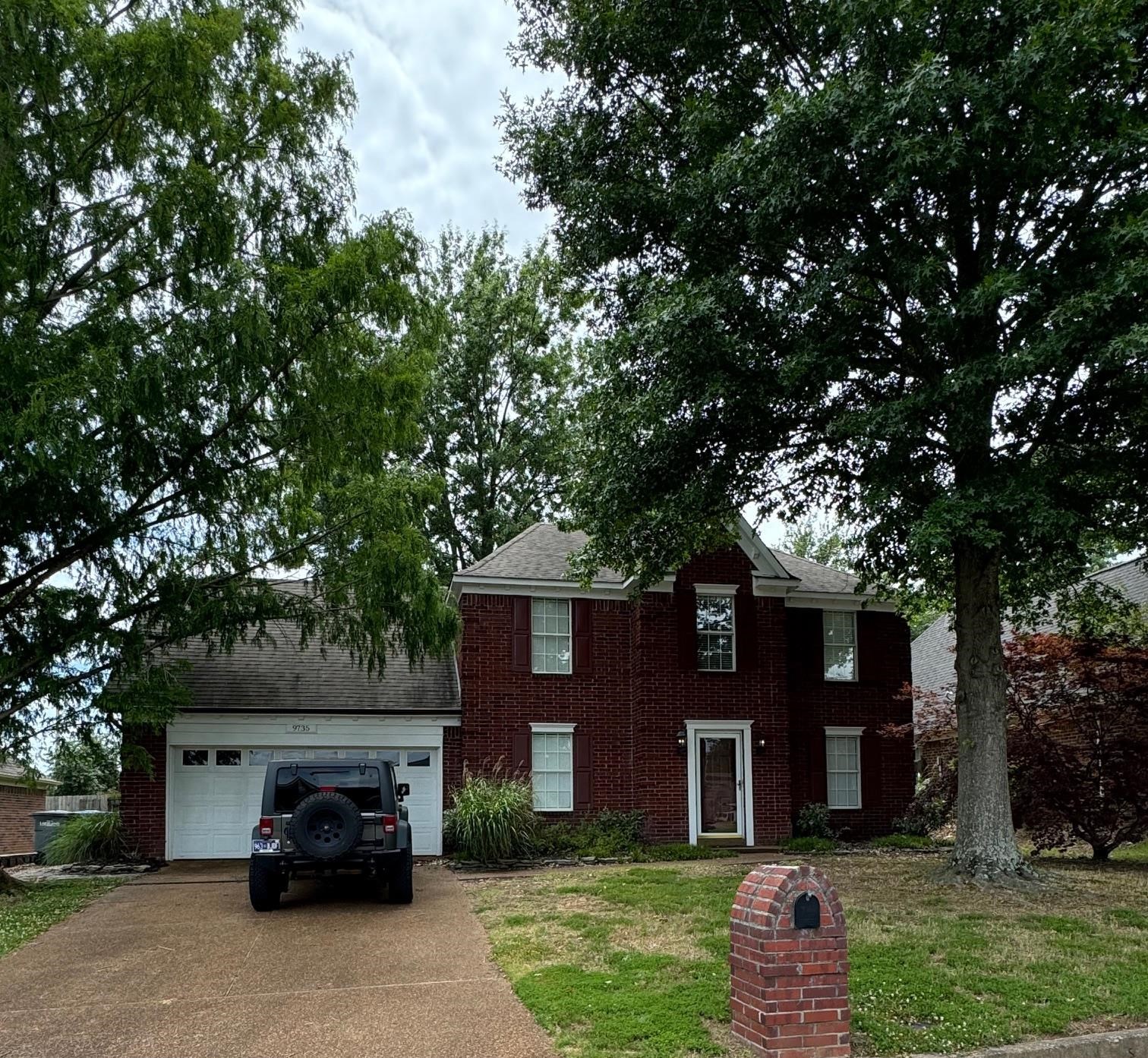 Colonial-style house with a garage and a front yard