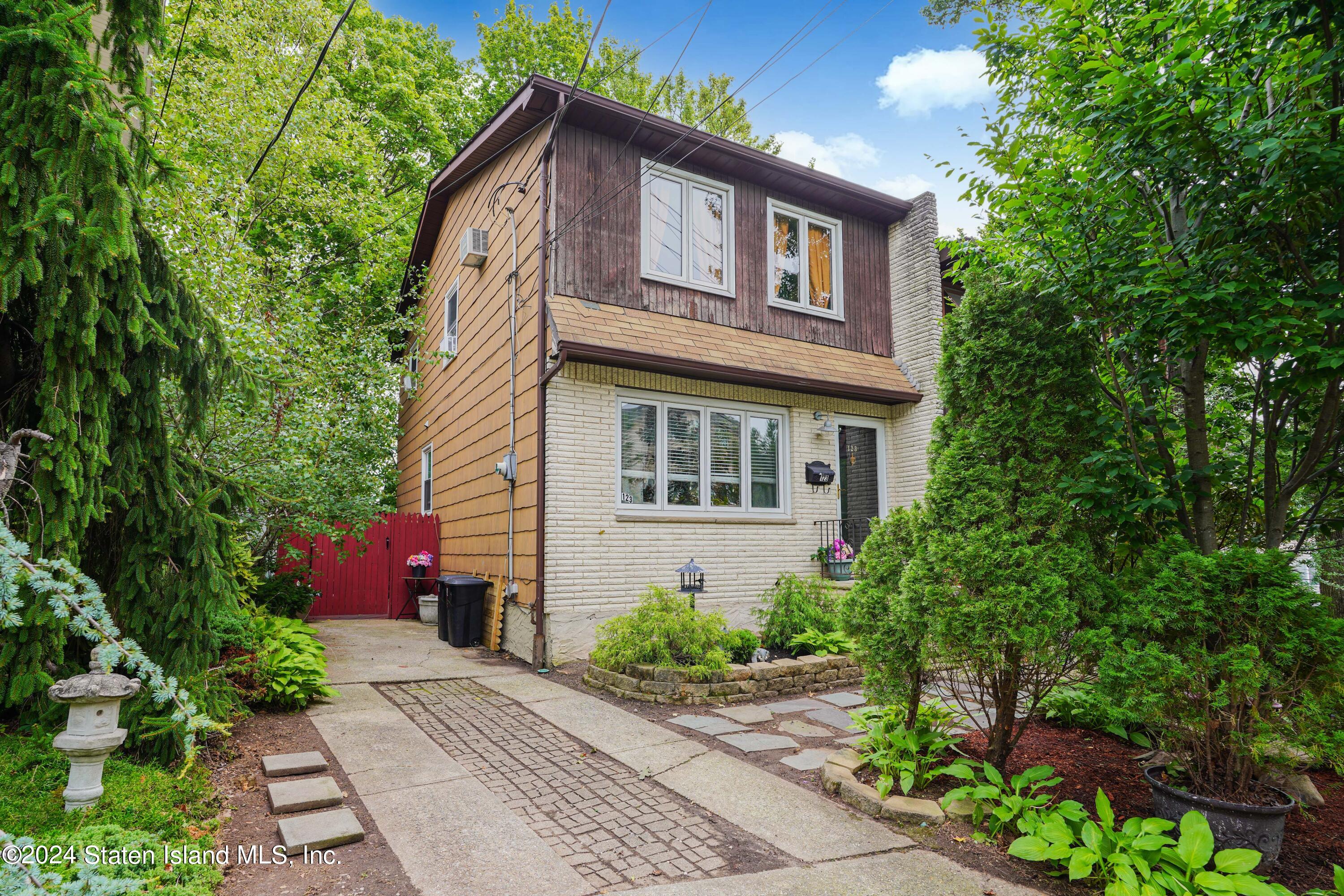 a front view of a house with plants and garden