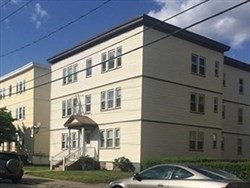 a front view of a residential apartment building with a yard