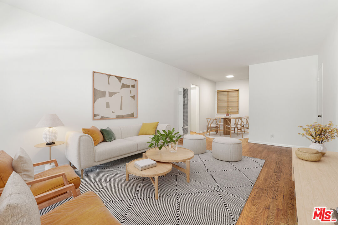 a living room with furniture a rug and a potted plant