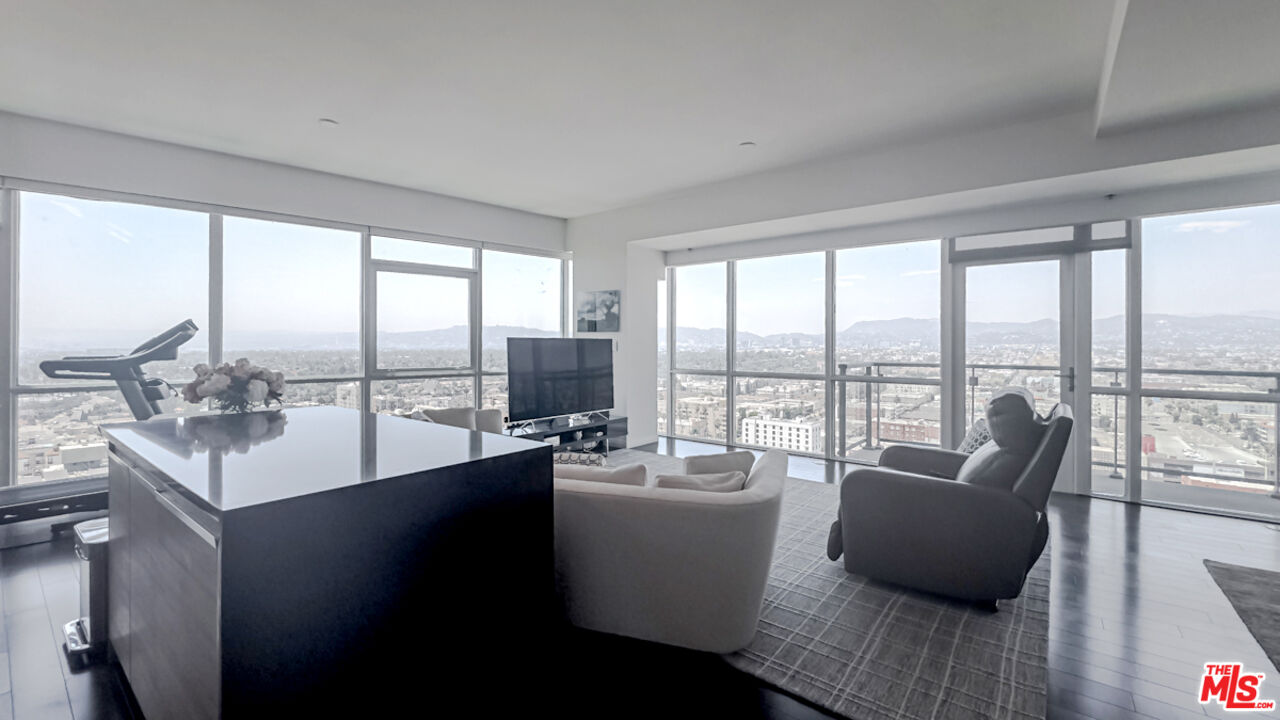 a living room with furniture and floor to ceiling windows