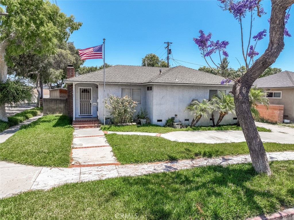 a front view of a house with a yard and potted plants