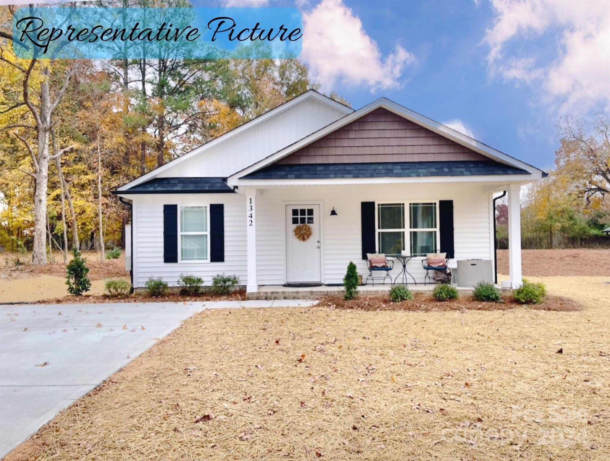 a front view of a house with a yard outdoor seating and a tree