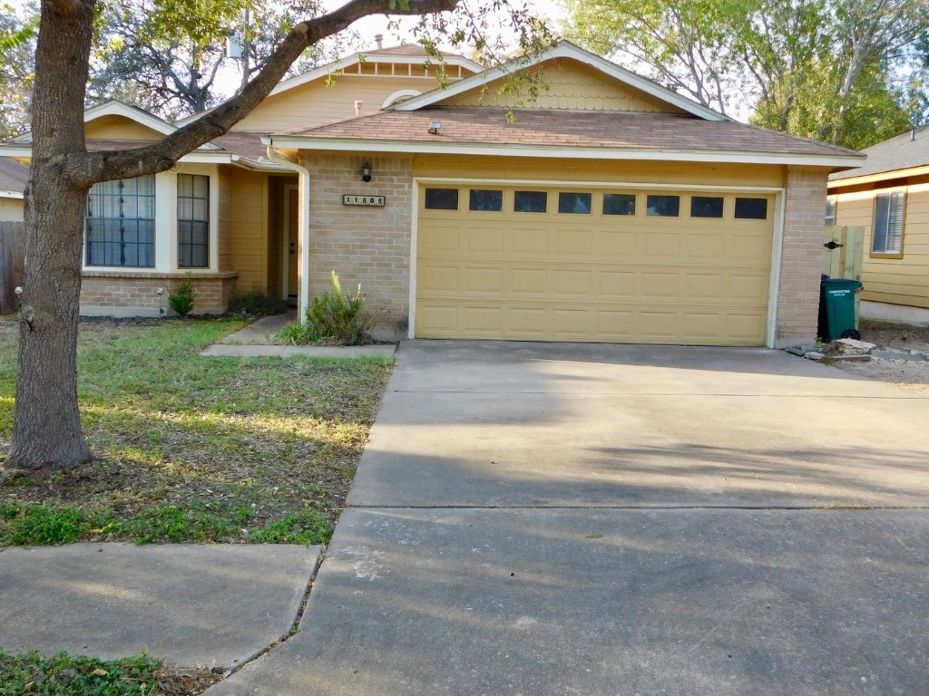 a front view of a house with a garden and trees