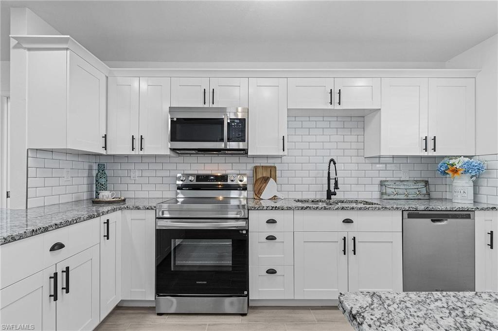 a kitchen with stainless steel appliances granite countertop a stove sink and cabinets