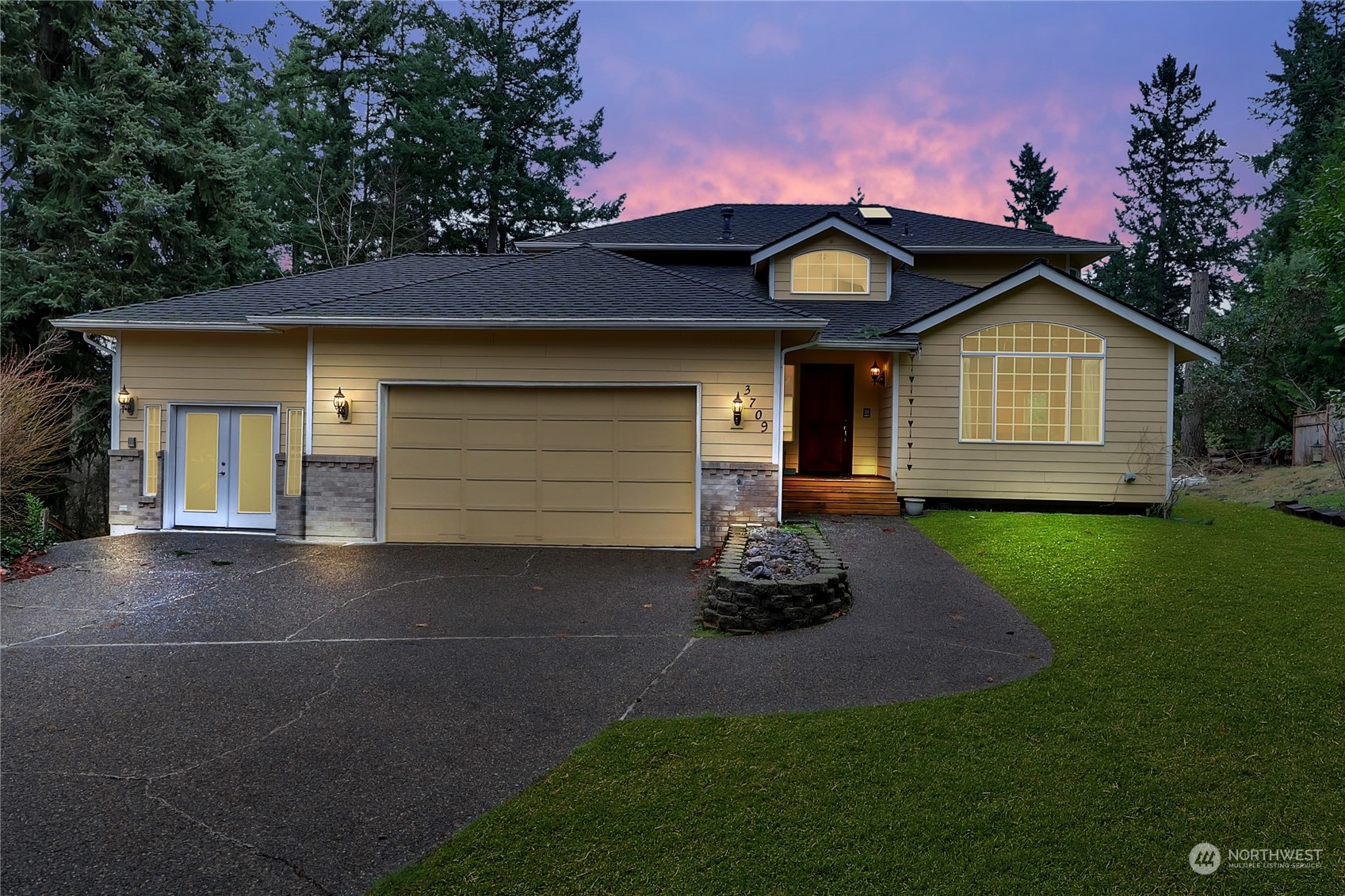 a front view of a house with a garden and yard