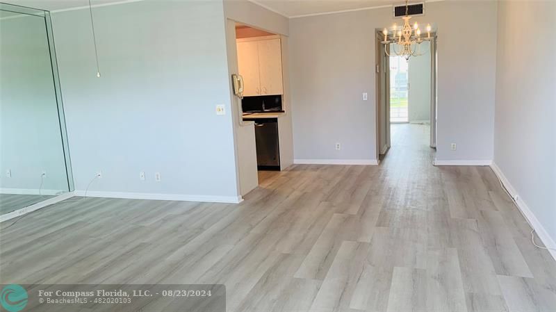 an empty room with wooden floor and entrance