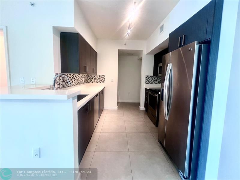 a kitchen with a refrigerator and a sink