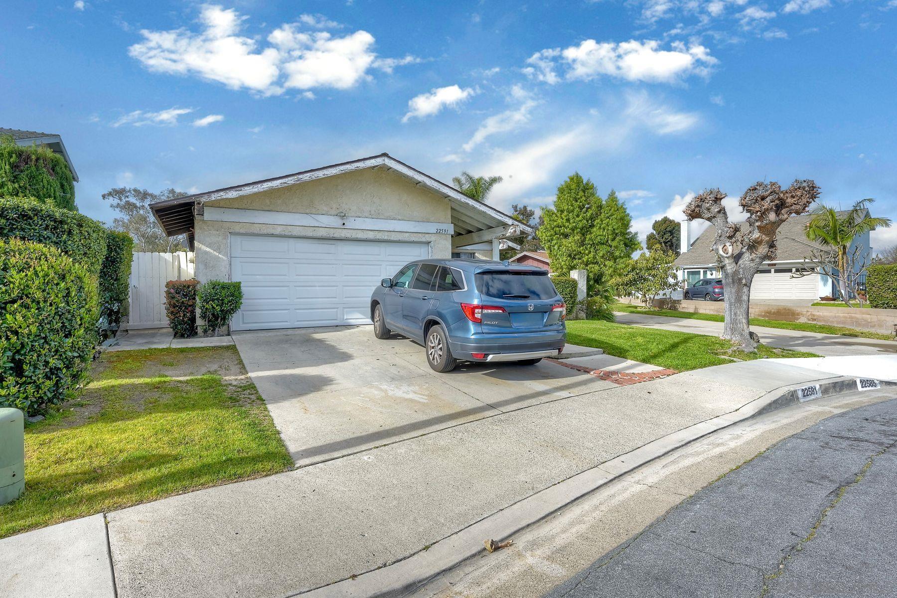 a car parked in front of house with a yard