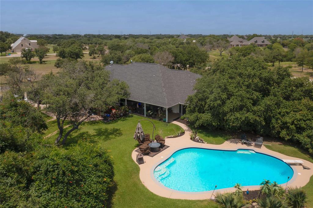 an aerial view of a house with a swimming pool and garden