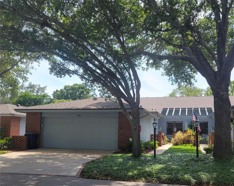 a view of a house with a yard and a large tree