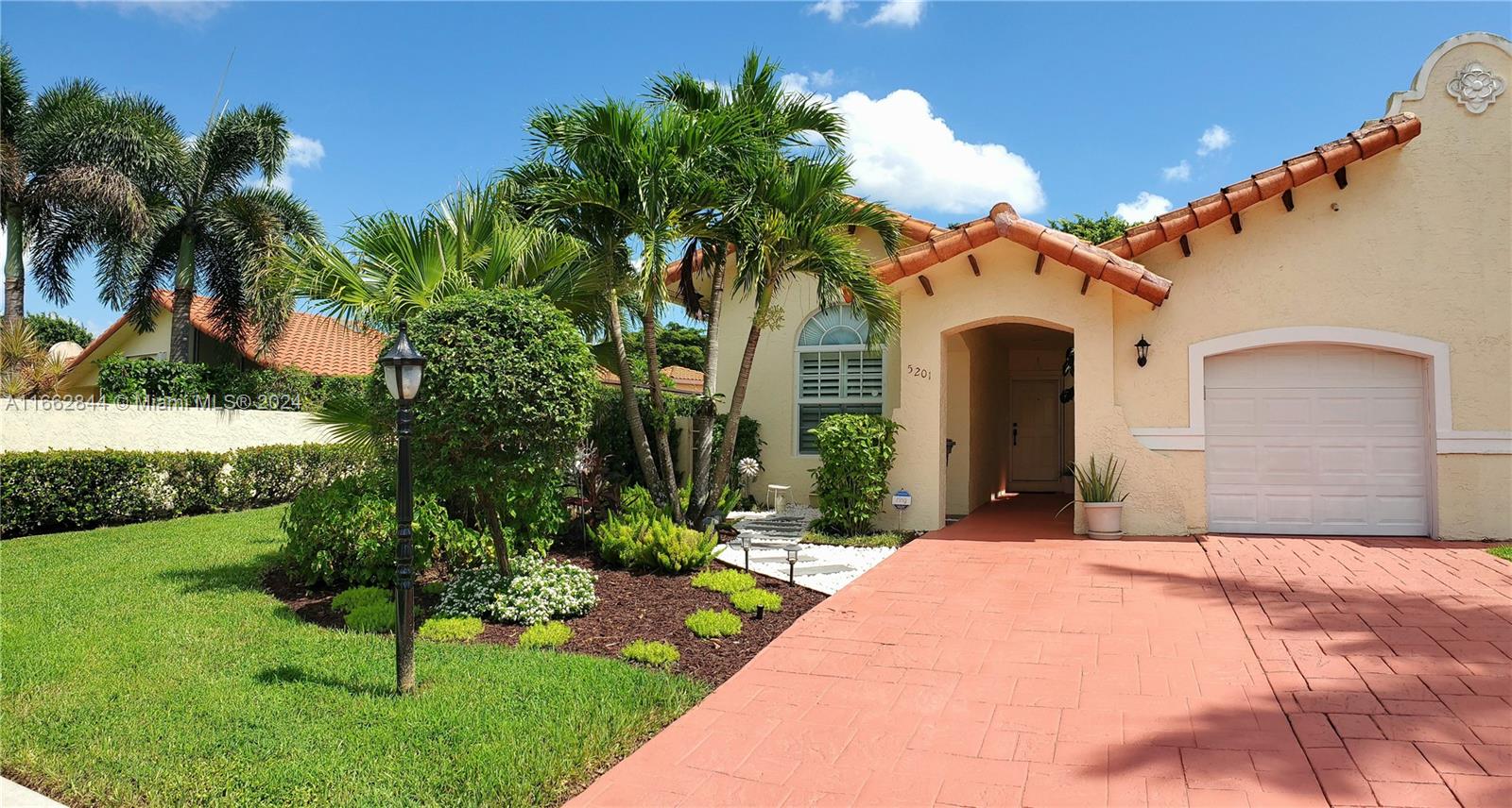 a front view of a house with a yard and potted plants