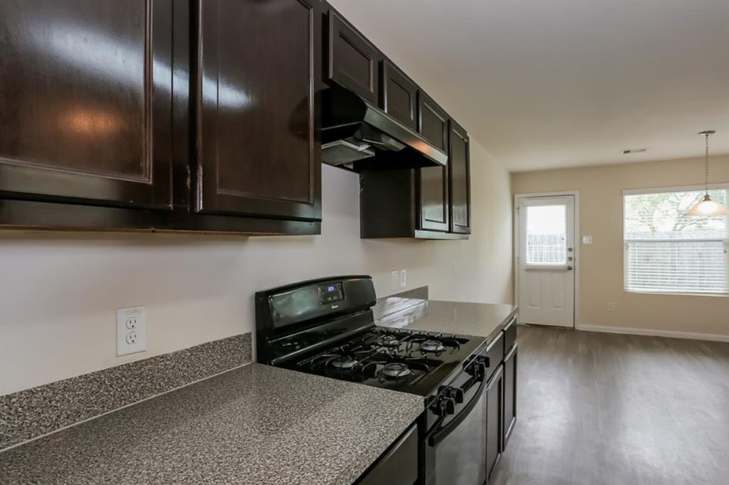 a kitchen with granite countertop stainless steel appliances a stove a sink and a window