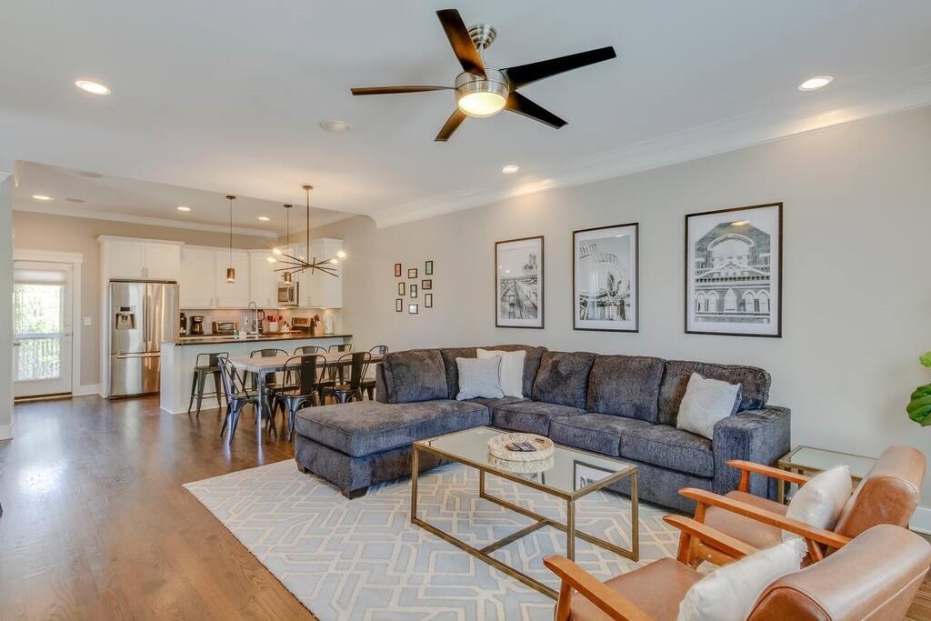 a living room with furniture kitchen view and a window