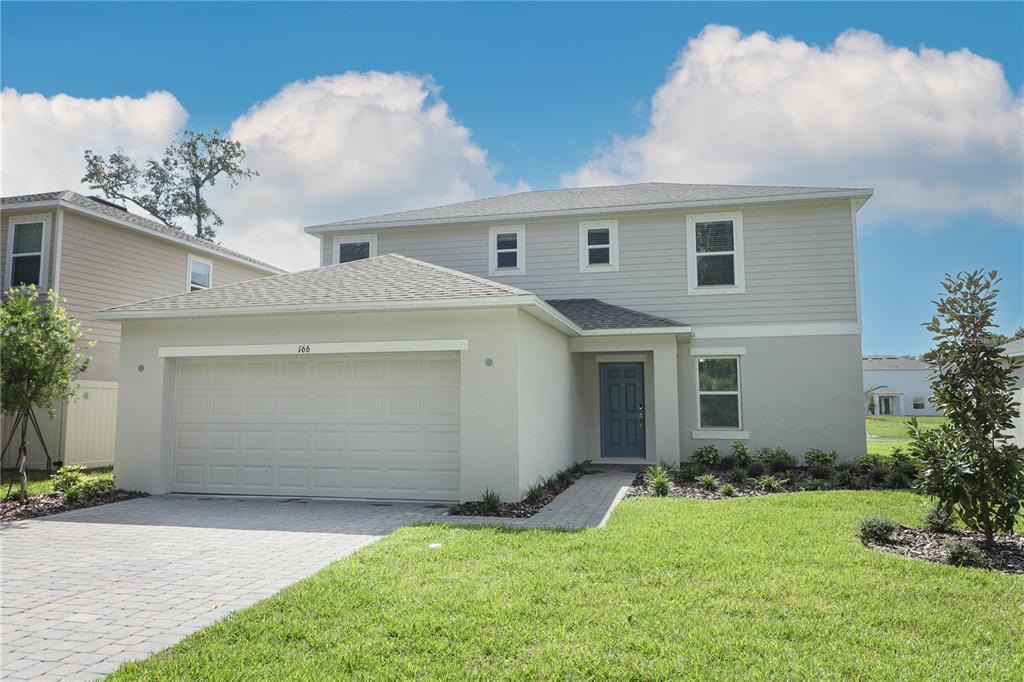 a view of a house with a yard and garage