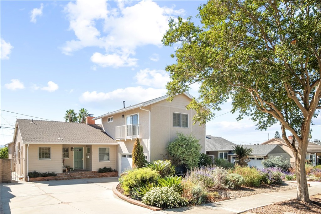 a front view of a house with a yard and potted plants