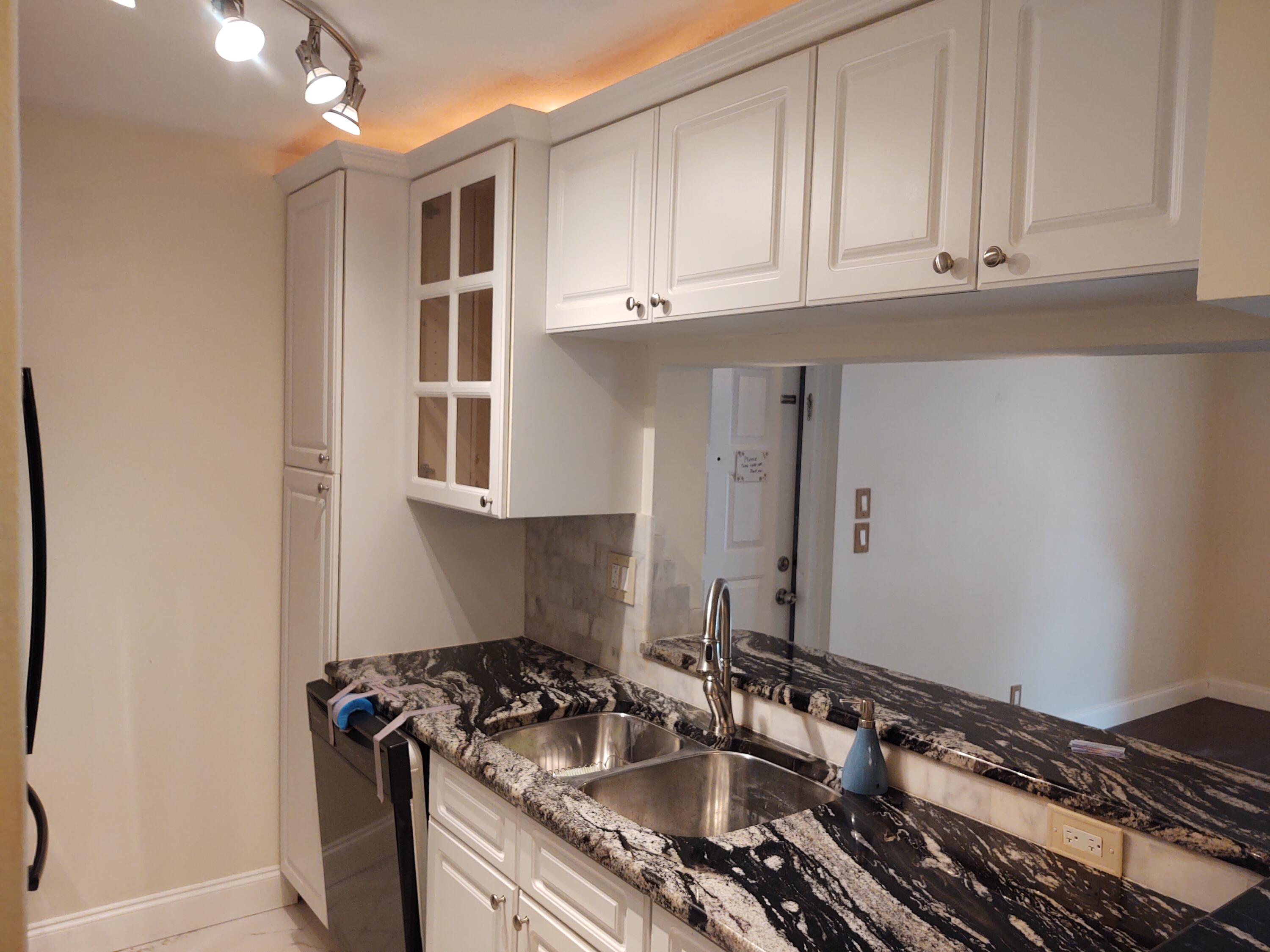 a kitchen with granite countertop a sink stove and cabinets