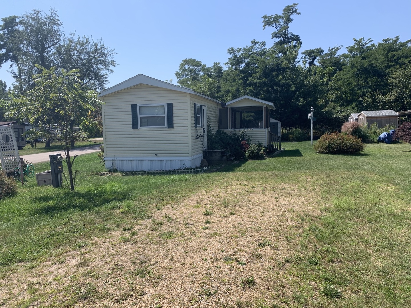 a view of a house with a yard and large trees