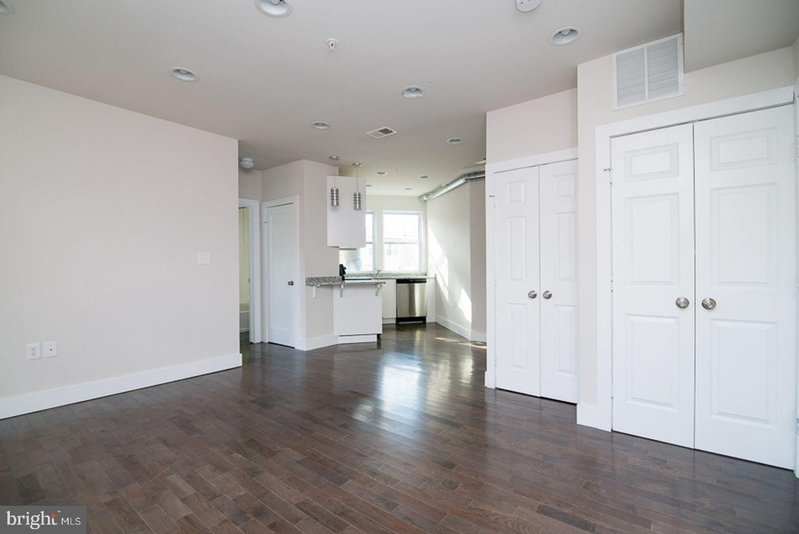 a view of an empty room with wooden floor