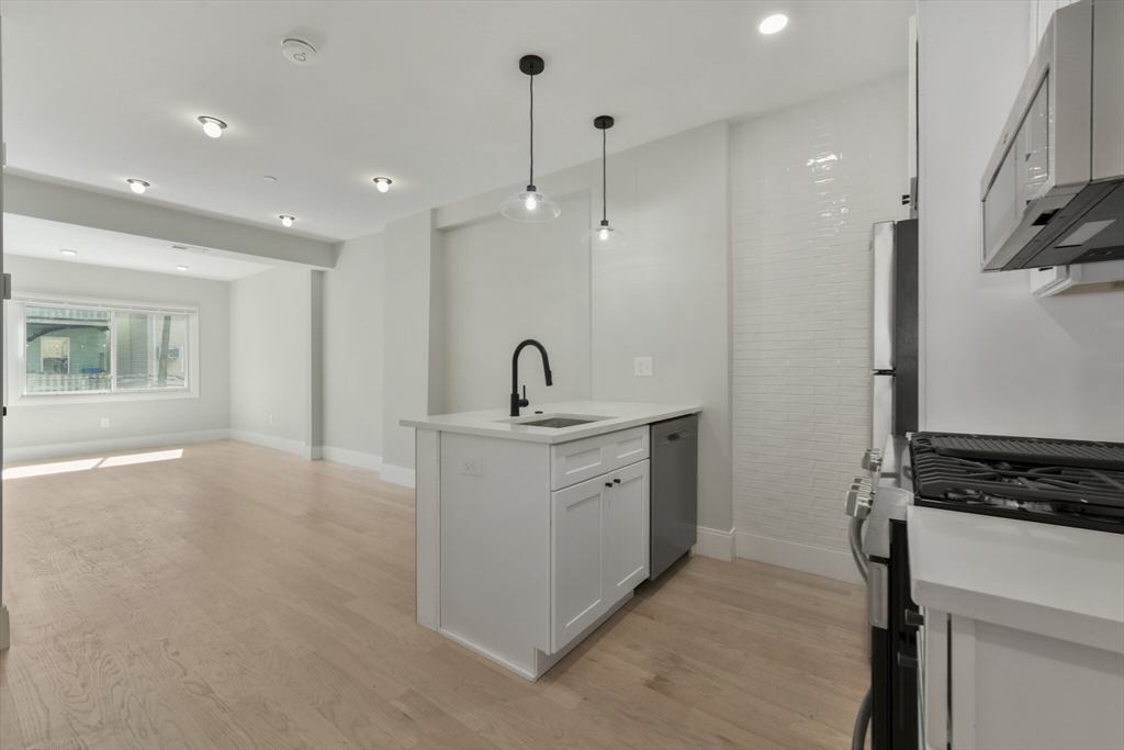 a kitchen with white cabinets and sink