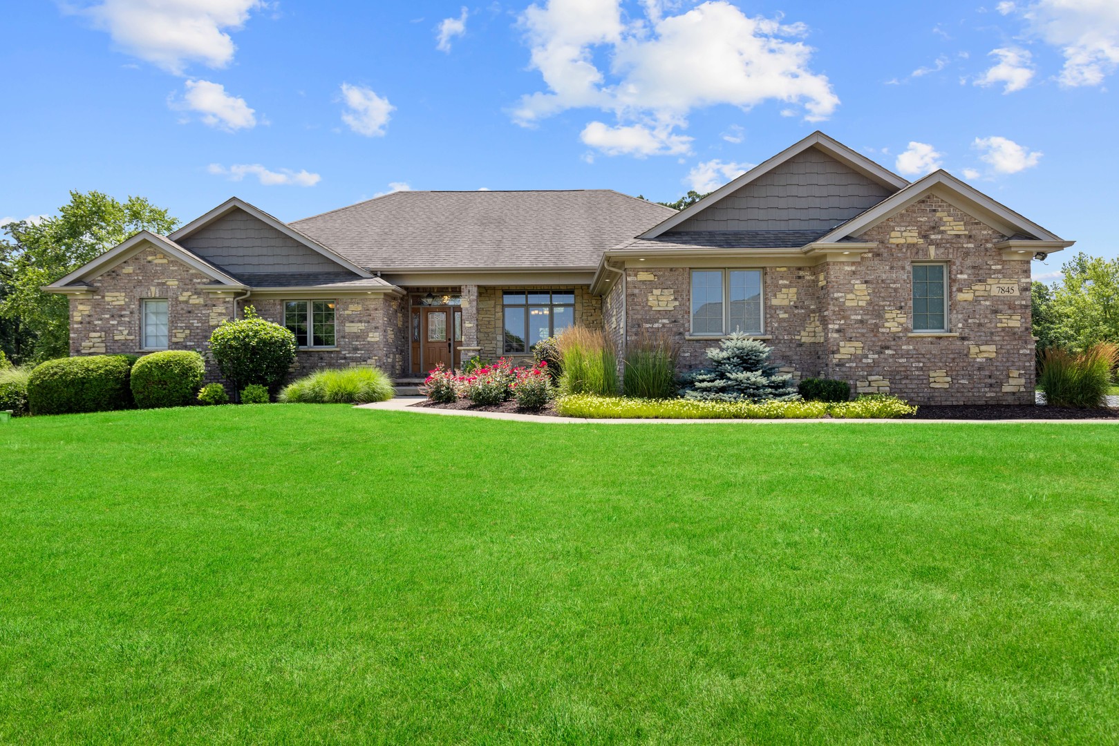 a front view of a house with a garden and plants